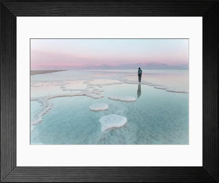Framed Print : Young woman standing on salt formations in dead sea at sunset Framed Print : Young woman standing on salt formations in dead sea at sunset