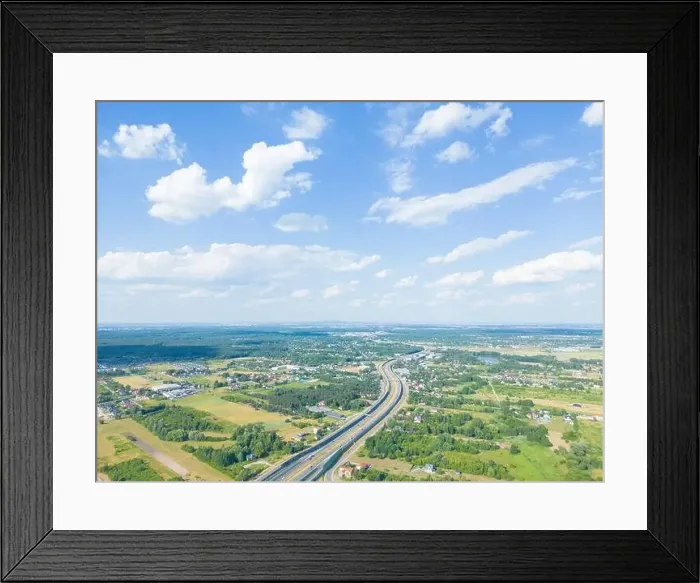 Framed Print : Aerial view of road in green meadows at sunset in summer Framed Print : Aerial view of road in green meadows at sunset in summer