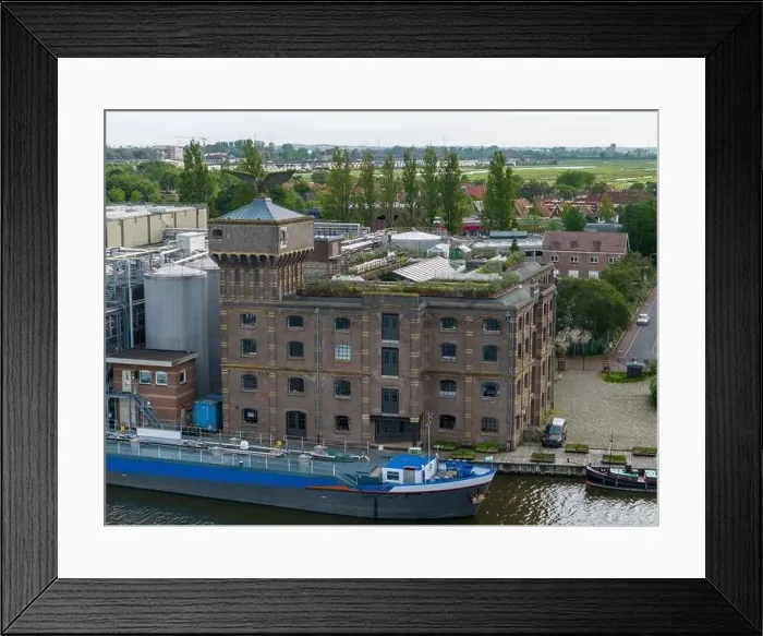 Framed Print : Aerial drone photo of a cargo barge docked at an industrial zone in Wormerveer, the Netherlands Framed Print : Aerial drone photo of a cargo barge docked at an industrial zone in Wormerveer, the Netherlands