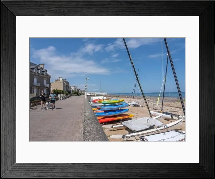 Framed Print : Saint-Aubin-Sur-Mer, France - 07 25 2023: A man and a woman with a white dog are running on the jetty Framed Print : Saint-Aubin-Sur-Mer, France - 07 25 2023: A man and a woman with a white dog are running on the jetty