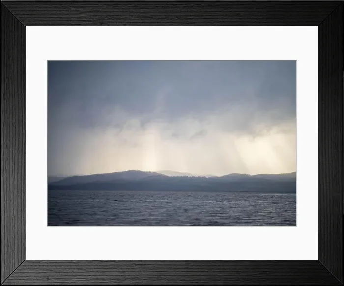 Framed Print : rays through clouds over the water