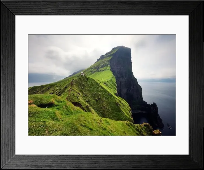 Framed Print : lighthouse sitting on top of a grassy hill close to a rocky black cliff looks over the tranquil sea on cloudy day Framed Print : lighthouse sitting on top of a grassy hill close to a rocky black cliff looks over the tranquil sea on cloudy day