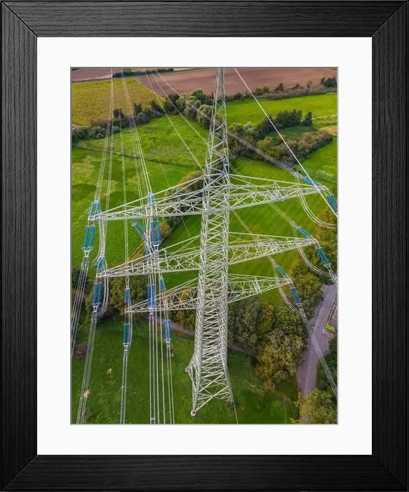 Framed Print : Drone shot of high voltage pylon with many power lines in green nature as conflict of technology and civilization Framed Print : Drone shot of high voltage pylon with many power lines in green nature as conflict of technology and civilization
