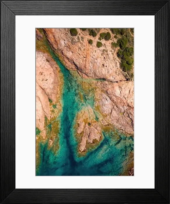 Framed Print : From above aerial view of a rocky coastline with turquoise waters and scattered vegetation in Sardinia, Italy Framed Print : From above aerial view of a rocky coastline with turquoise waters and scattered vegetation in Sardinia, Italy