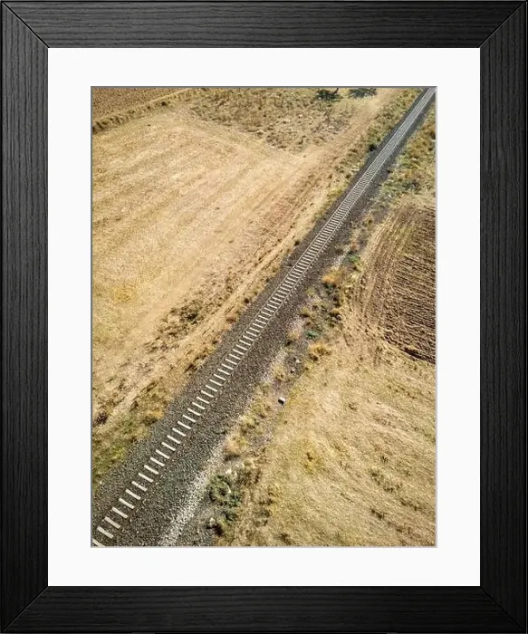 Framed Print : Top view of the train track passing through the arid land, taken with a drone Framed Print : Top view of the train track passing through the arid land, taken with a drone