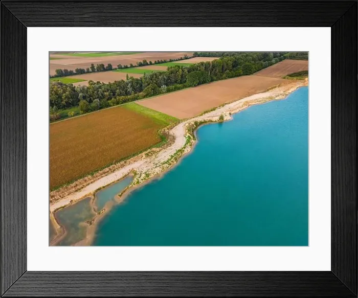 Framed Print : Fields and a forest next to the shore of an artificial lake with turquoise water in fall seen from above by a drone Framed Print : Fields and a forest next to the shore of an artificial lake with turquoise water in fall seen from above by a drone