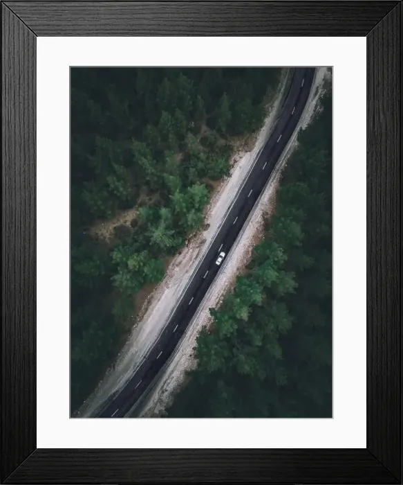 Framed Print : Aerial view taken by drone of a car driving on a forest road in autumn Framed Print : Aerial view taken by drone of a car driving on a forest road in autumn