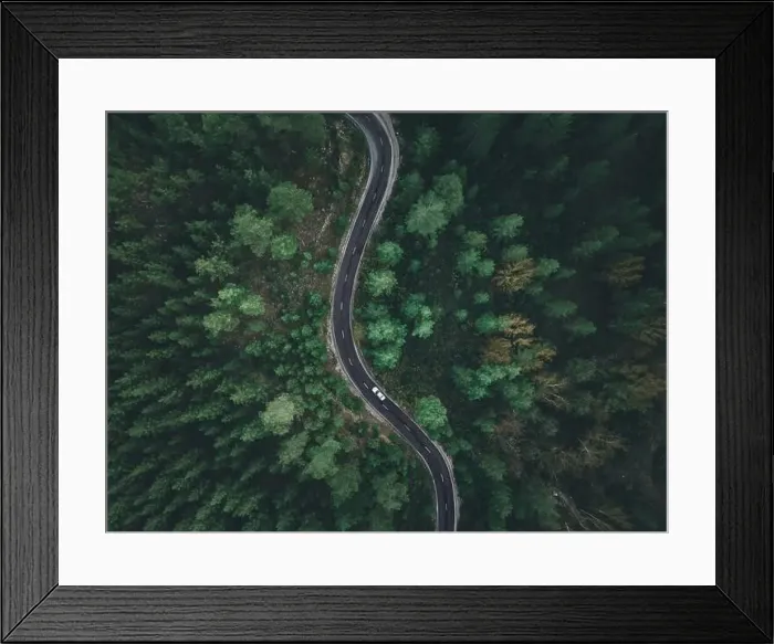 Framed Print : Aerial view taken by drone of a car driving on a forest road in autumn Framed Print : Aerial view taken by drone of a car driving on a forest road in autumn