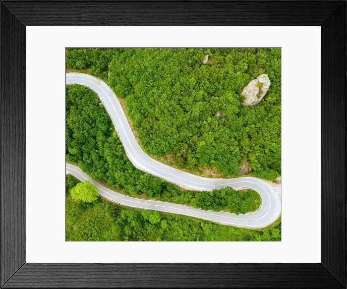 Framed Print : A gracefully curved road cuts through a vibrant Framed Print : A gracefully curved road cuts through a vibrant