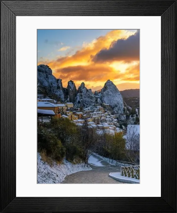 Framed Print : Steep road leads down into Castlemzzano village in winter with a colourful sunrise sky above Framed Print : Steep road leads down into Castlemzzano village in winter with a colourful sunrise sky above