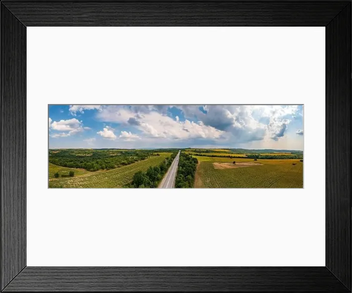 Framed Print : Panoramic aerial view of road between fields. Birds-eye view of the land with fields, meadows, and forest Framed Print : Panoramic aerial view of road between fields. Birds-eye view of the land with fields, meadows, and forest