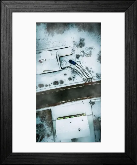 Framed Print : Aerial shot of a street covered with snow next to two A shaped house and a car Framed Print : Aerial shot of a street covered with snow next to two A shaped house and a car