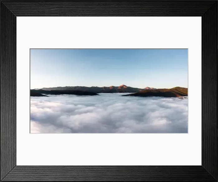 Framed Print : Foggy mountain landscape above the clouds at sunset. Aerial view. Mountain peaks stick out from the clouds Framed Print : Foggy mountain landscape above the clouds at sunset. Aerial view. Mountain peaks stick out from the clouds