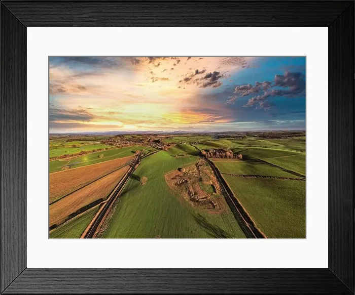 Framed Print : Aerial view of a lush countryside at sunset with vibrant skies and patchwork fields Framed Print : Aerial view of a lush countryside at sunset with vibrant skies and patchwork fields