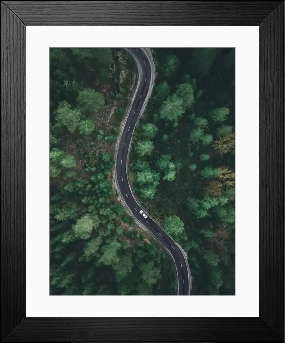Framed Print : Aerial view taken by drone of a car driving on a forest road in autumn