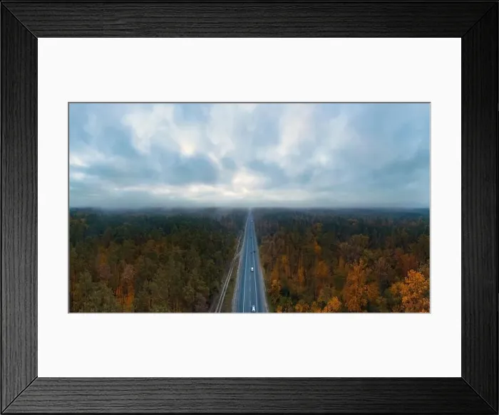 Framed Print : Highway road with passing cars in autumn forest with dark moody sky with clouds from aerial view Framed Print : Highway road with passing cars in autumn forest with dark moody sky with clouds from aerial view