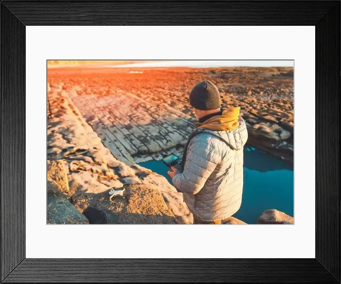 Framed Print : Bearded man using a drone with remote controller making photos and videos, having fun with new technology trends Framed Print : Bearded man using a drone with remote controller making photos and videos, having fun with new technology trends