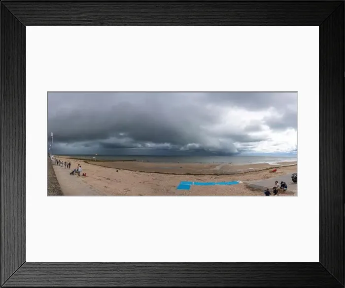 Framed Print : Langrune-Sur-Mer, France - 07 26 2023: View of the sea, the jetty and people walking on the beach with a cloudy sky Framed Print : Langrune-Sur-Mer, France - 07 26 2023: View of the sea, the jetty and people walking on the beach with a cloudy sky