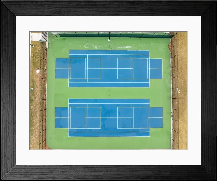 Framed Print : Aerial photo of unusually painted outdoor blue tennis courts with yellow pickleball lines and green out of bounds area Framed Print : Aerial photo of unusually painted outdoor blue tennis courts with yellow pickleball lines and green out of bounds area