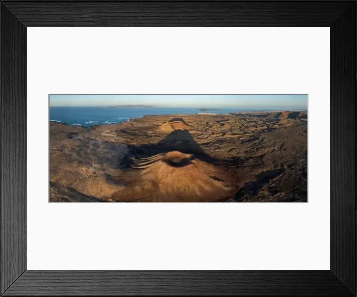 Framed Print : The aerial image captures a vast volcanic landscape bathed in the warm light of sunset Framed Print : The aerial image captures a vast volcanic landscape bathed in the warm light of sunset
