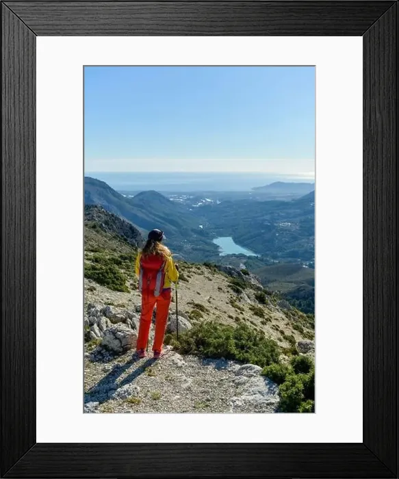 Framed Print : A woman standing on a rocky point overlooking Mediterranean sea Framed Print : A woman standing on a rocky point overlooking Mediterranean sea