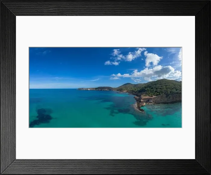 Framed Print : aerial view the green and rugged hilly coast of northern Ibiza with the turquoise waters of Cala Xarraca bay Framed Print : aerial view the green and rugged hilly coast of northern Ibiza with the turquoise waters of Cala Xarraca bay
