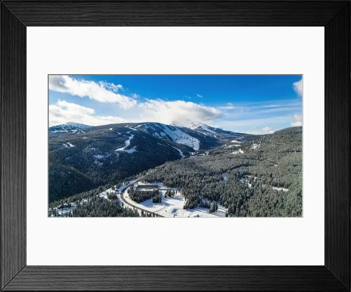 Framed Print : Aerial view traffic road through the snowy mountains with pine trees Framed Print : Aerial view traffic road through the snowy mountains with pine trees