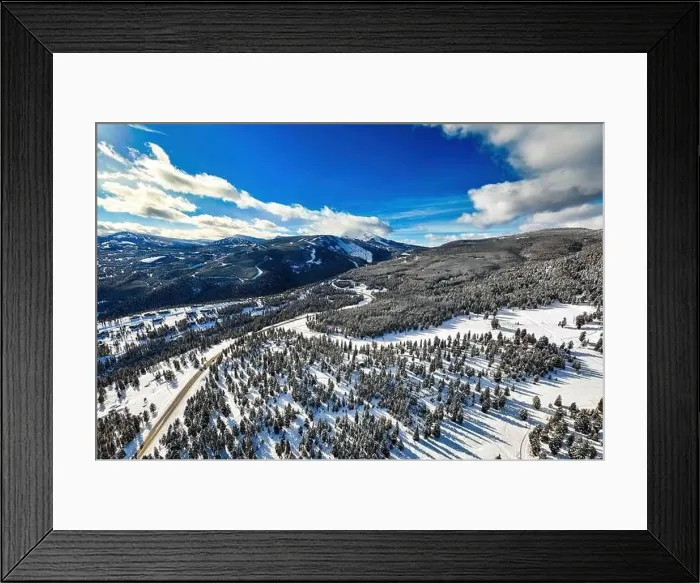 Framed Print : Aerial view traffic road through the snowy mountains with pine trees Framed Print : Aerial view traffic road through the snowy mountains with pine trees