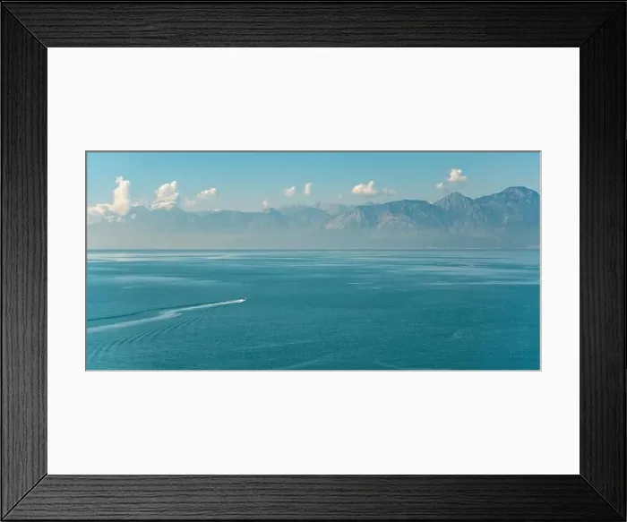 Framed Print : Antalya landscape with a boat sailing on the sea and mountains in the background Framed Print : Antalya landscape with a boat sailing on the sea and mountains in the background