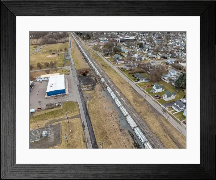 Framed Print : Sayre, PA, USA - 03-03-2024 - Cloudy winter aerial image of a bulk materials railroad car near downtown area in