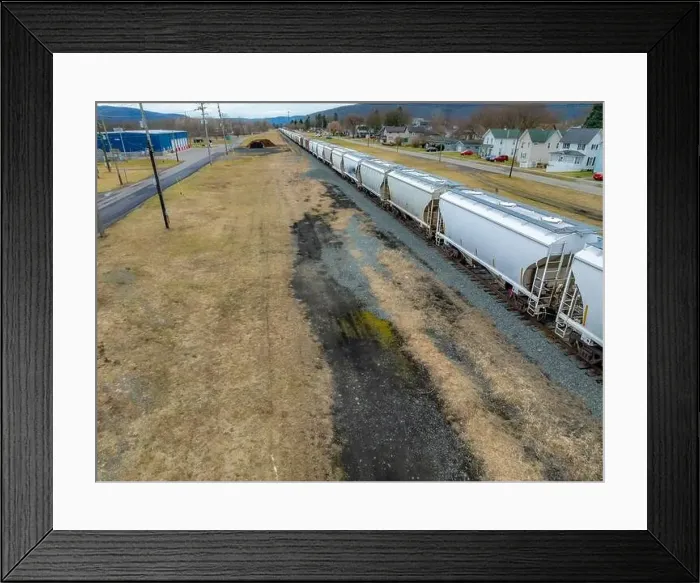 Framed Print : Sayre, PA, USA - 03-03-2024 - Cloudy winter aerial image of a bulk materials railroad car near downtown area in Framed Print : Sayre, PA, USA - 03-03-2024 - Cloudy winter aerial image of a bulk materials railroad car near downtown area in
