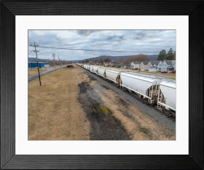 Framed Print : Sayre, PA, USA - 03-03-2024 - Cloudy winter aerial image of a bulk materials railroad car near downtown area in Framed Print : Sayre, PA, USA - 03-03-2024 - Cloudy winter aerial image of a bulk materials railroad car near downtown area in