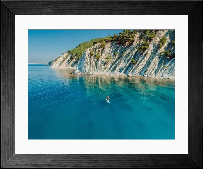 Framed Print : Paddle boarding in Mediterranean sea with mountain coastline. Aerial view Framed Print : Paddle boarding in Mediterranean sea with mountain coastline. Aerial view