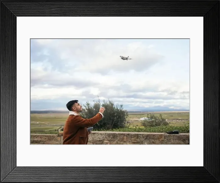 Framed Print : Young man using a drone to record and photograph the landscape Framed Print : Young man using a drone to record and photograph the landscape