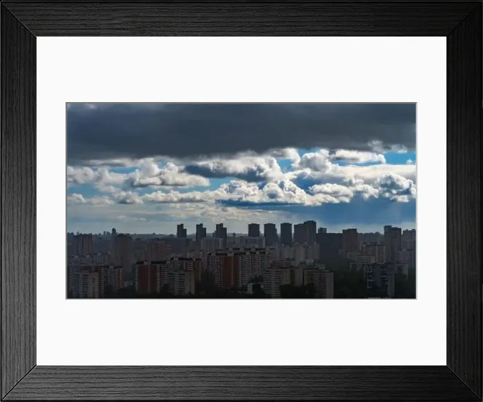 Framed Print : Panoramic view of Moscow's multi-storey buildings covered with the shadow of a storm cloud against the background of Framed Print : Panoramic view of Moscow's multi-storey buildings covered with the shadow of a storm cloud against the background of