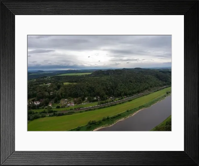 Framed Print : A train is traveling down a train track next to a river Framed Print : A train is traveling down a train track next to a river