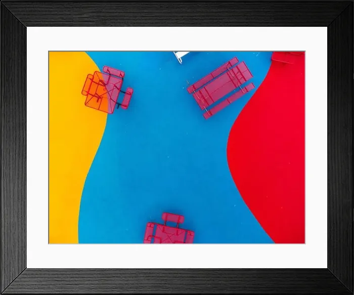 Framed Print : Aerial, drone, photo, of a red vinyl coated picnic tables on a multi color playground surface Framed Print : Aerial, drone, photo, of a red vinyl coated picnic tables on a multi color playground surface