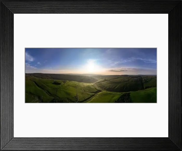 Framed Print : An expansive drone shot captures the beauty of a green valley bathed in sunlight with undulating hills and clear skies Framed Print : An expansive drone shot captures the beauty of a green valley bathed in sunlight with undulating hills and clear skies