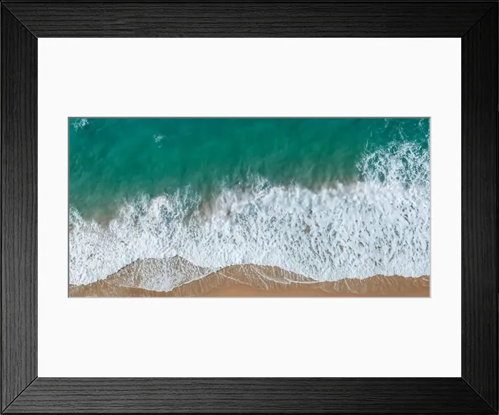 Framed Print : Waves crash onto sandy shores from a top perspective Framed Print : Waves crash onto sandy shores from a top perspective