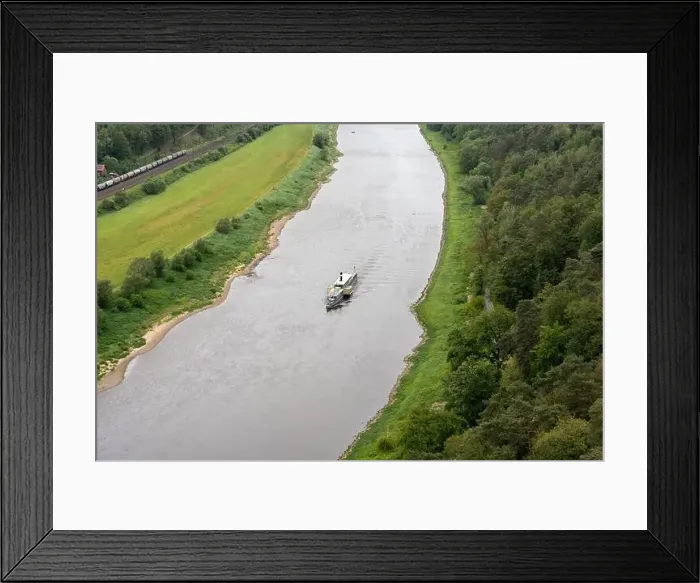 Framed Print : A boat is traveling down a river Framed Print : A boat is traveling down a river