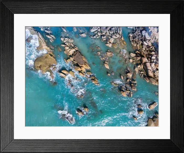 Framed Print : Aerial drone top view of beautiful waves crashing on the rocky island coast Framed Print : Aerial drone top view of beautiful waves crashing on the rocky island coast