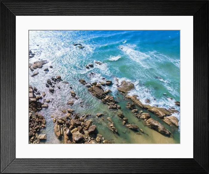 Framed Print : Aerial drone top view of beautiful waves crashing on the rocky island coast Framed Print : Aerial drone top view of beautiful waves crashing on the rocky island coast