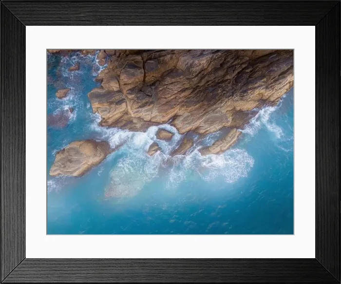 Framed Print : Aerial drone top view of beautiful waves crashing on the rocky island coast Framed Print : Aerial drone top view of beautiful waves crashing on the rocky island coast