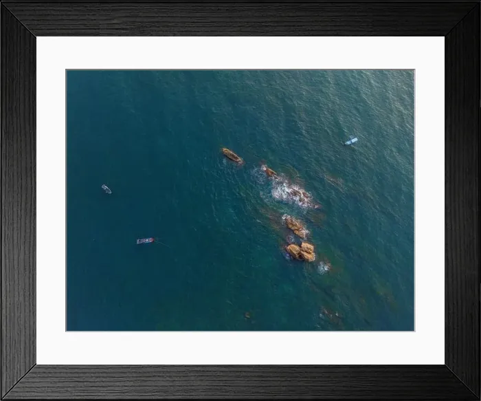 Framed Print : Aerial drone top view of beautiful waves crashing on the rocky island coast Framed Print : Aerial drone top view of beautiful waves crashing on the rocky island coast