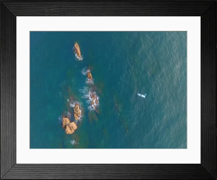 Framed Print : Aerial drone top view of beautiful waves crashing on the rocky island coast Framed Print : Aerial drone top view of beautiful waves crashing on the rocky island coast