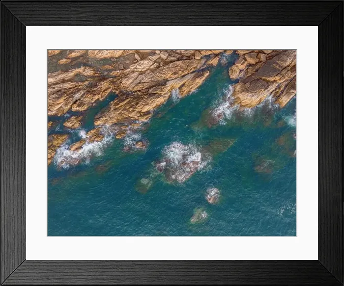 Framed Print : Aerial drone top view of beautiful waves crashing on the rocky island coast Framed Print : Aerial drone top view of beautiful waves crashing on the rocky island coast
