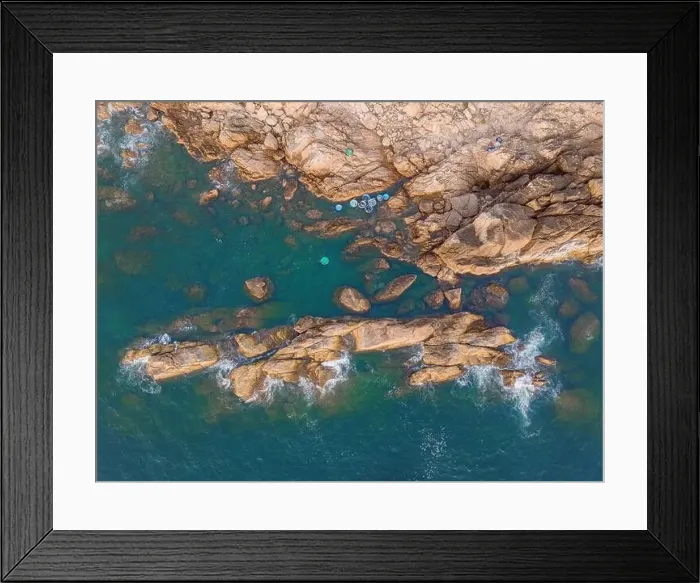Framed Print : Aerial drone top view of beautiful waves crashing on the rocky island coast Framed Print : Aerial drone top view of beautiful waves crashing on the rocky island coast