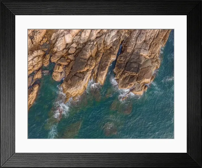 Framed Print : Aerial drone top view of beautiful waves crashing on the rocky island coast Framed Print : Aerial drone top view of beautiful waves crashing on the rocky island coast