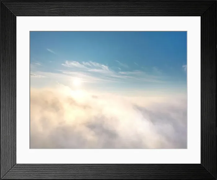 Framed Print : View from above of fog or clouds with clear blue sky and rising sun in the background Framed Print : View from above of fog or clouds with clear blue sky and rising sun in the background