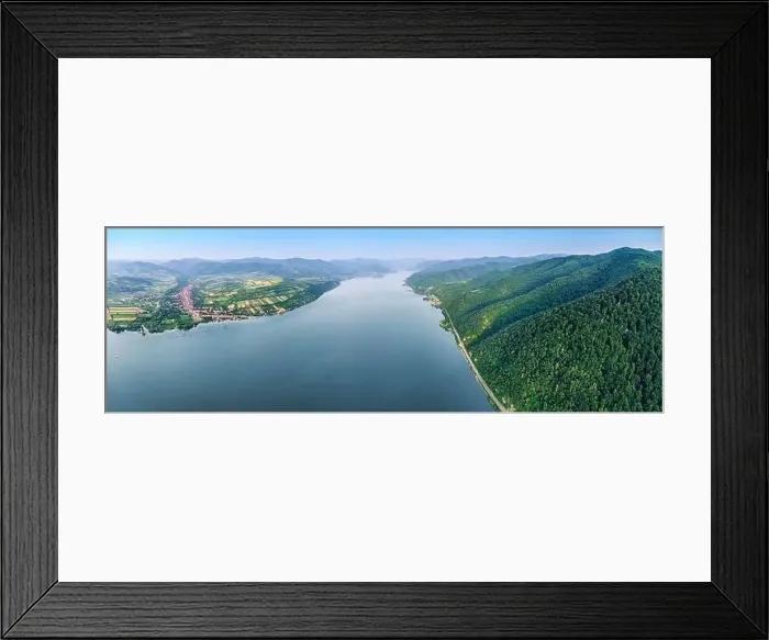 Framed Print : Beautiful landscape of a scenic town along the Danube River with green forests and blue waters Framed Print : Beautiful landscape of a scenic town along the Danube River with green forests and blue waters